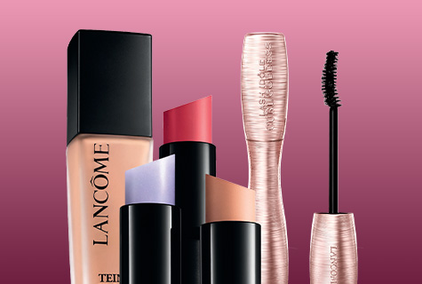 Lancôme Make-up Produkte: Foundation, Lippenstifte und Mascara vor pinkem Hintergrund